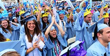 A group of Columbia University students in their caps and gowns at Commencement.