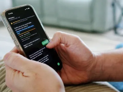Person on a cell phone looking at a toll charge scam message